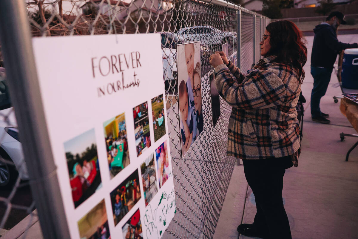 A mourner places a photograph on a fence during a vigil for Rebecca Post, Achilles Quintanilla ...