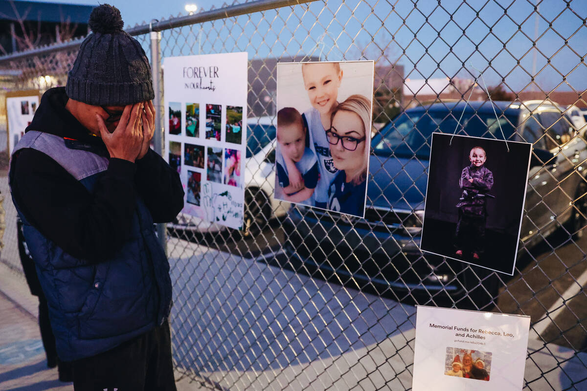 A mourner gets emotional in front of a fence that is decorated with photographs and posters dur ...