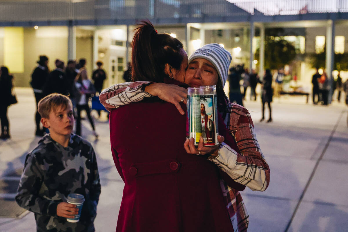 Mourners hug during a vigil for Rebecca Post, Achilles Quintanilla and Leo Post-Quintanilla at ...