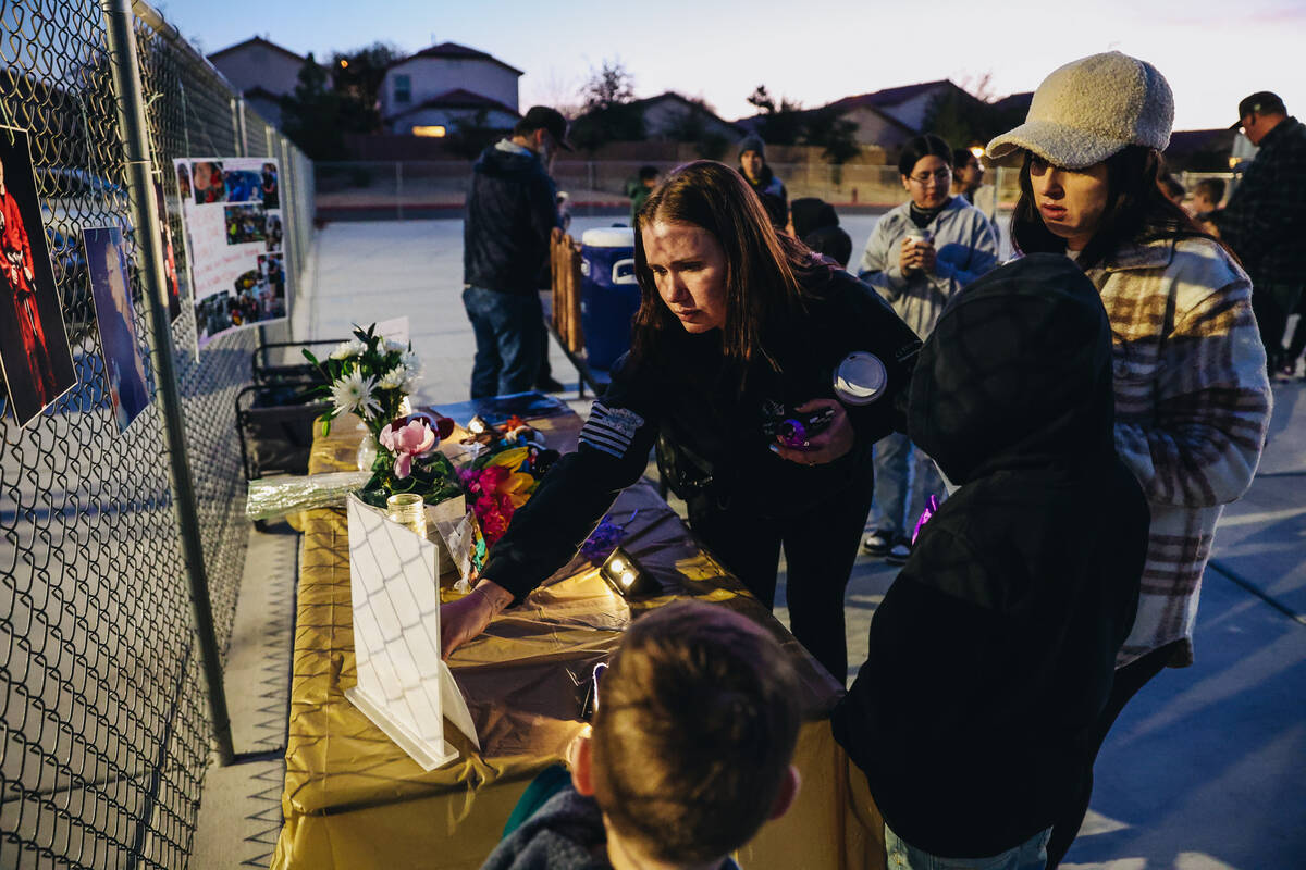 Mourners leave things on a memorial table during a vigil for Rebecca Post, Achilles Quintanilla ...