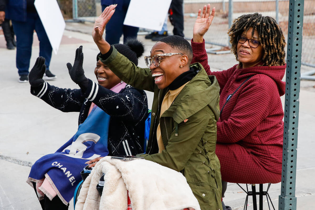 Lisa Fisher, from right, Kanjalia Stidhum, and Adleen Stidhum cheer on people during the annual ...