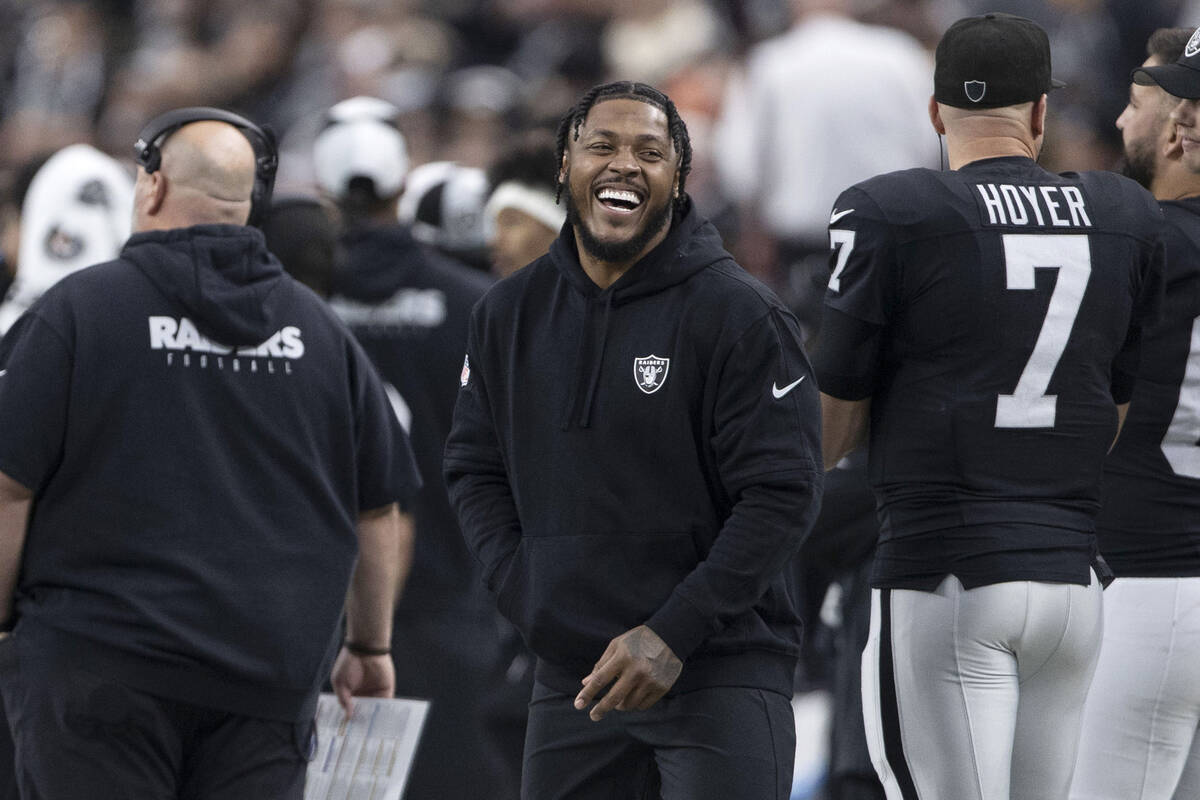 Raiders running back Josh Jacobs laughs on the sideline during the first half of an NFL game ag ...