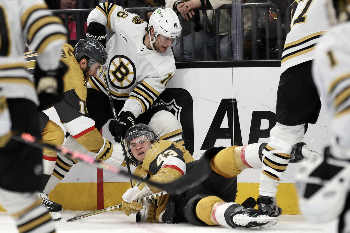 Golden Knights center Paul Cotter (43) falls to the ice after battling for the puck with Bruins ...