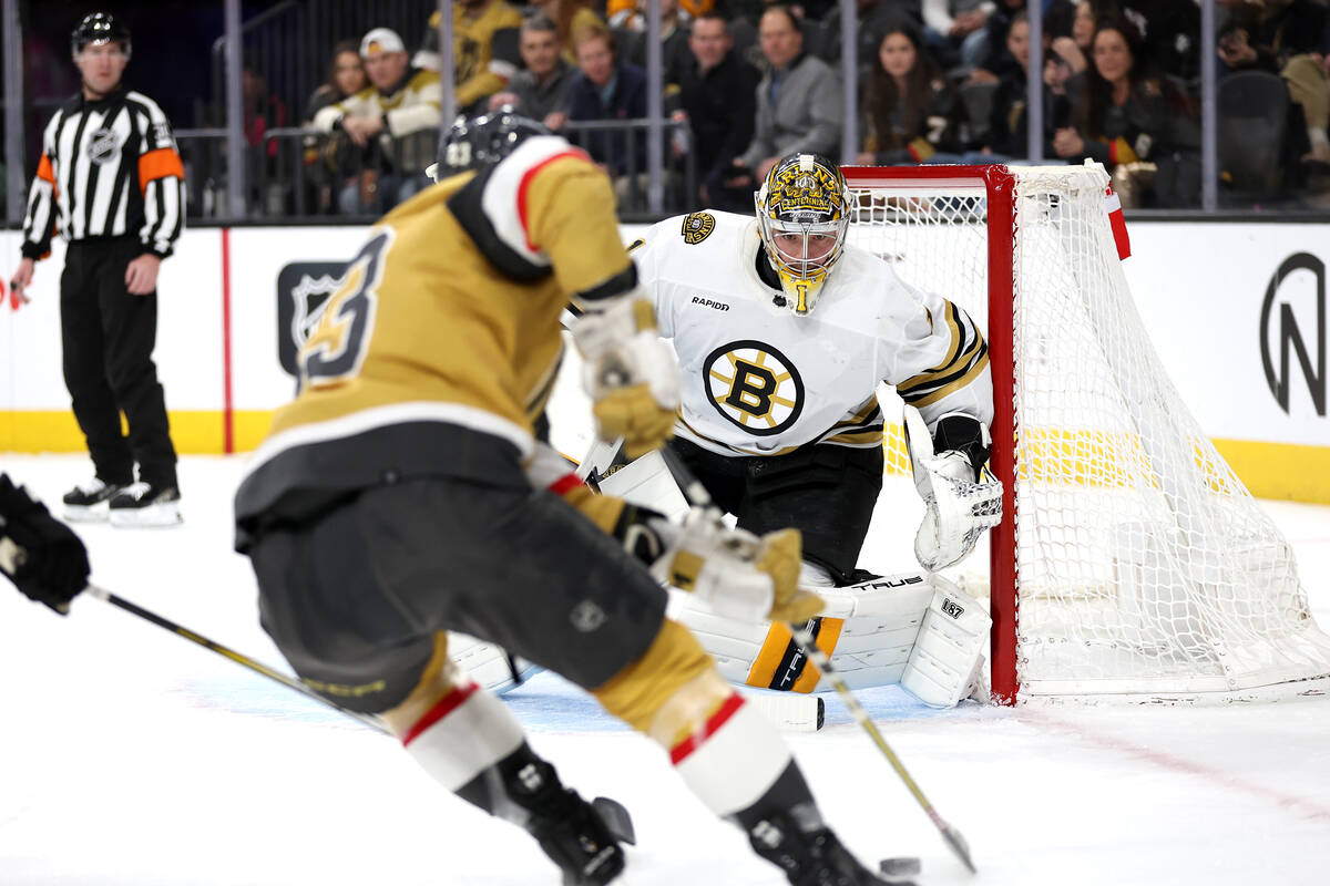 Bruins goaltender Jeremy Swayman (1) prepares to save a shot while Golden Knights center Paul C ...