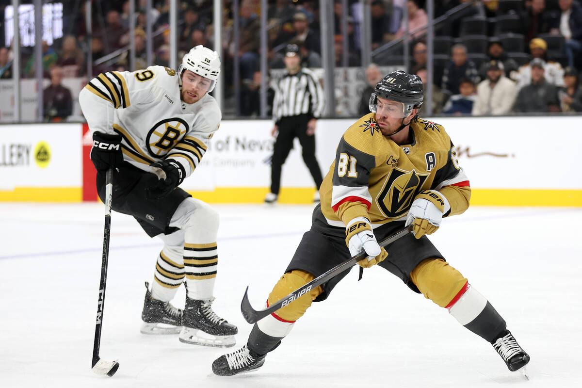 Bruins center Johnny Beecher (19) steals the puck from Golden Knights right wing Jonathan March ...