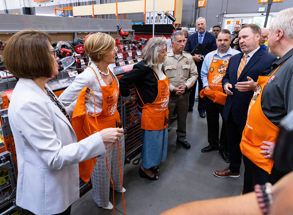 Scott Glenn, vice president of asset protection at the Home Depot, second right, leads a tour o ...
