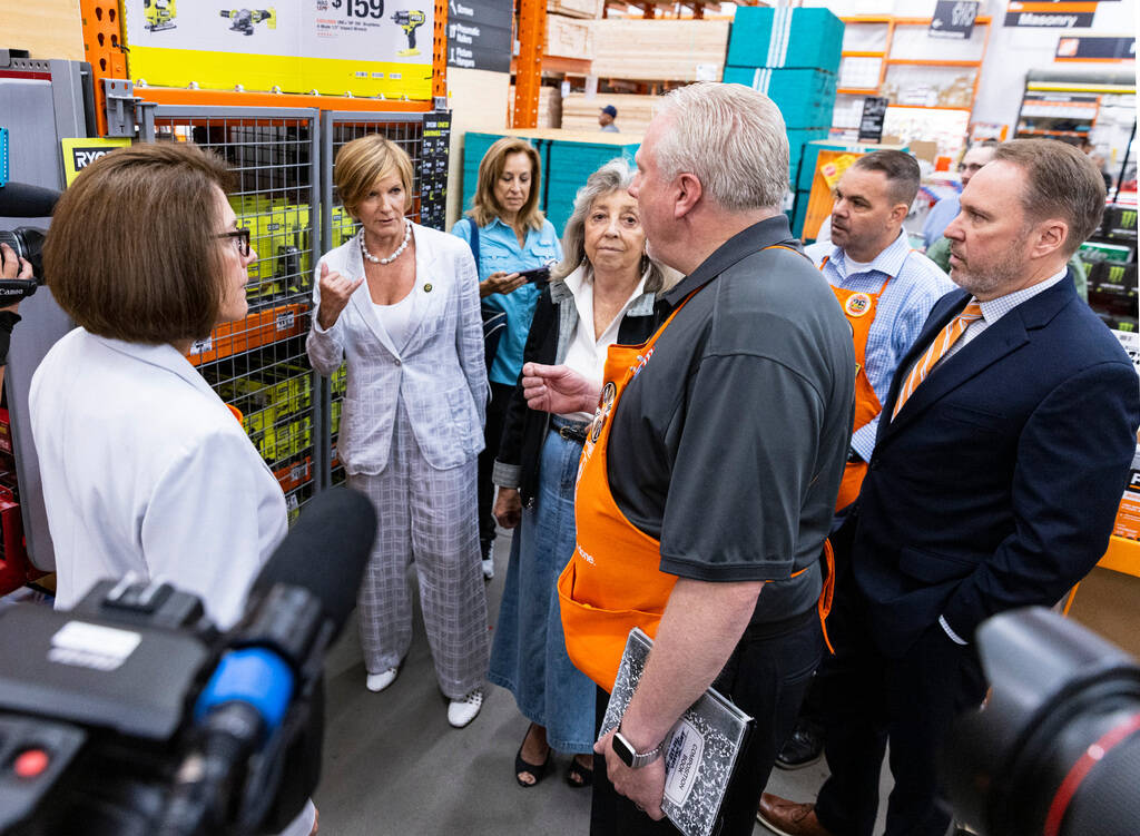 Larry Jensen, second right, a store manager at the Home Depot, leads a tour of his store as Sco ...
