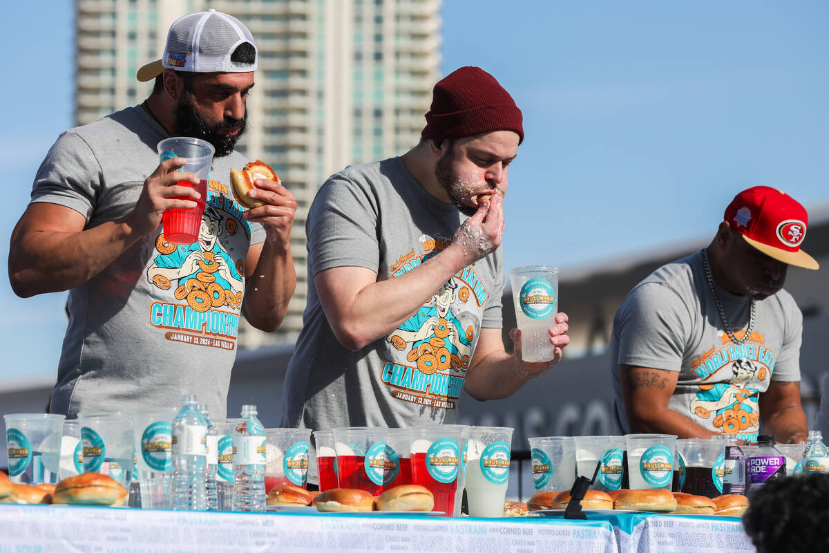 James Webb, left, and Patrick Bertoletti race to eat as many bagels with cream cheese as they c ...