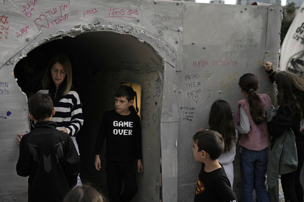 People writes messages on the wall after walking through an installation simulating a tunnel in ...
