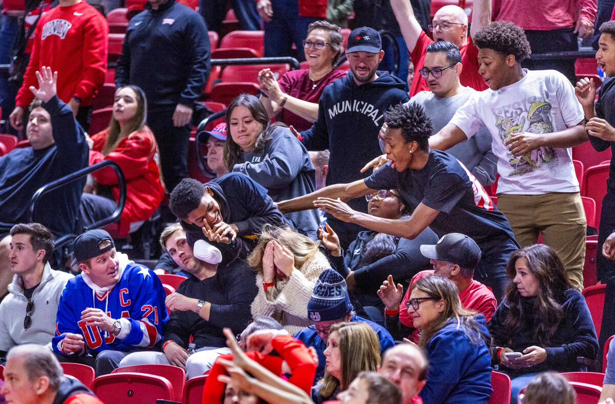 UNLV fans scramble for t-shirts tossed into the crowd in a timeout against the Utah State Aggie ...