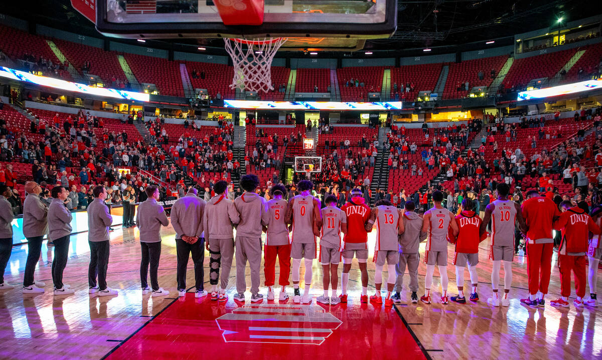 UNLV players and coaches stand for the National Anthem to face the Utah State Aggies during the ...