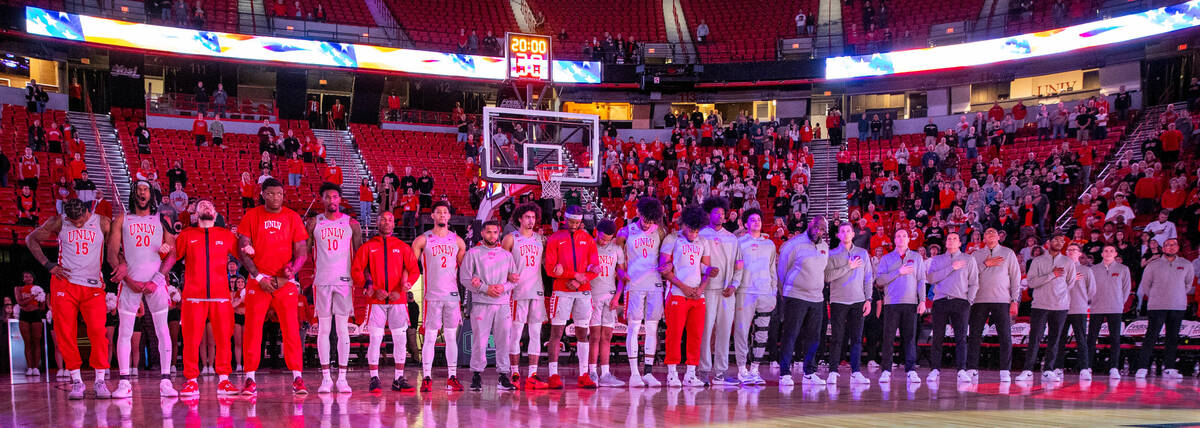 UNLV players and coaches stand for the National Anthem to face the Utah State Aggies during the ...