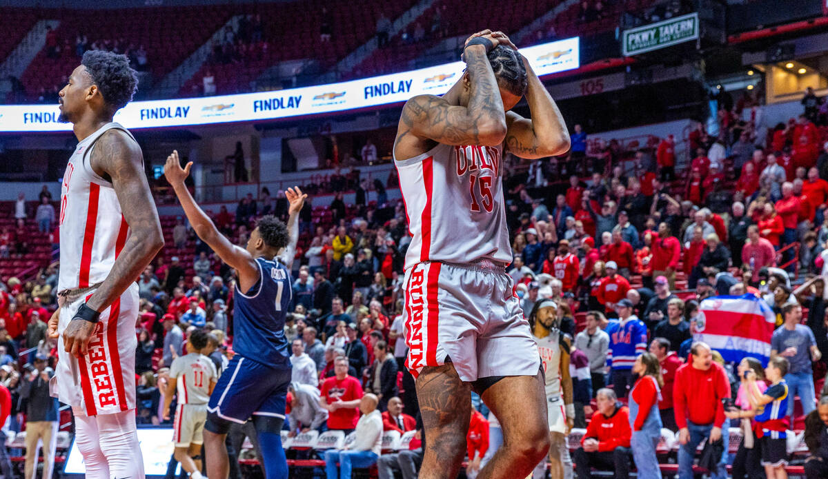 UNLV guard Luis Rodriguez (15) is dejected after a close loss as Utah State Aggies forward Grea ...