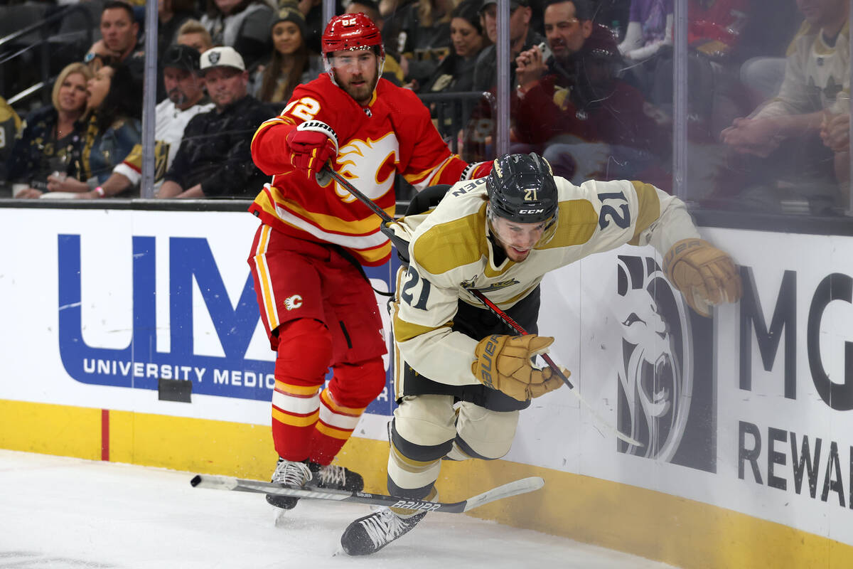 Golden Knights center Brett Howden (21) loses his stick while tangling with Flames defenseman J ...