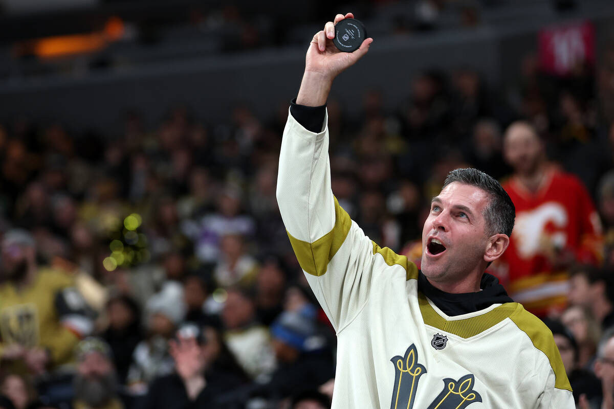 A Golden Knights fan shows off the errant puck he caught during the third period of an NHL hock ...