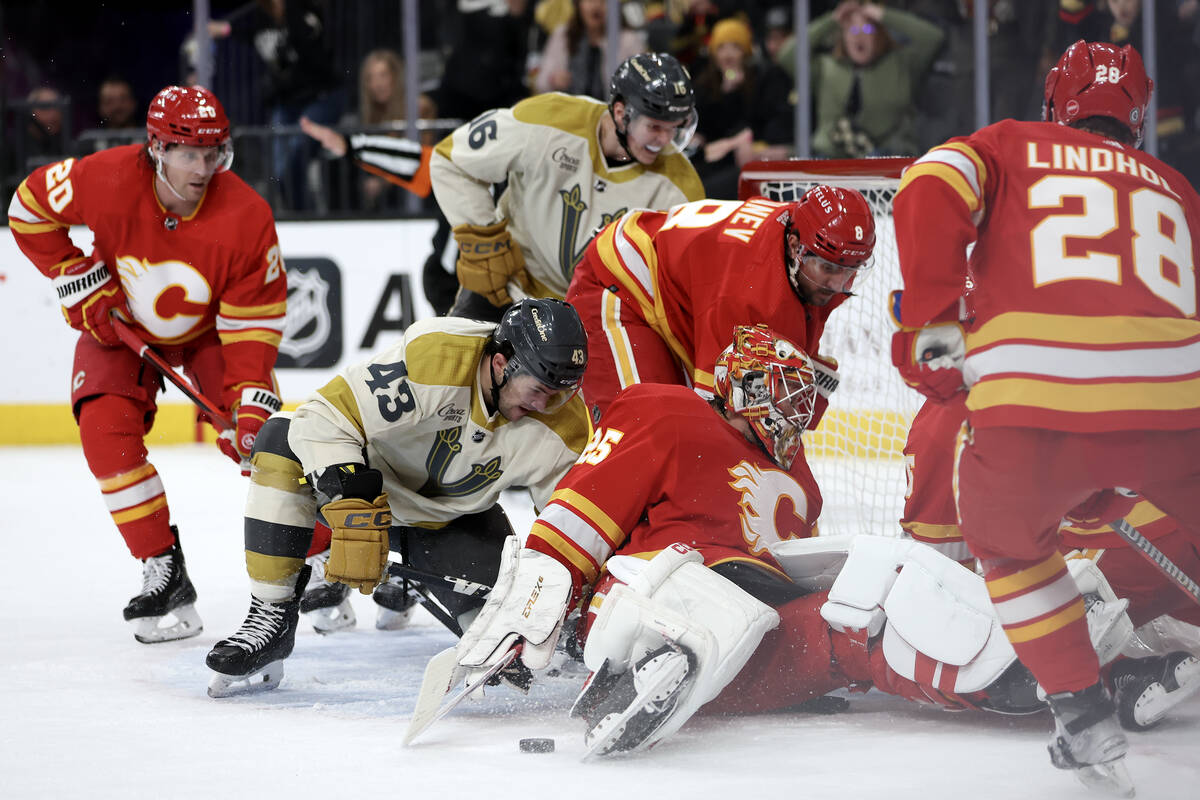 Golden Knights center Paul Cotter (43) battles for the puck with Flames goaltender Jacob Markst ...