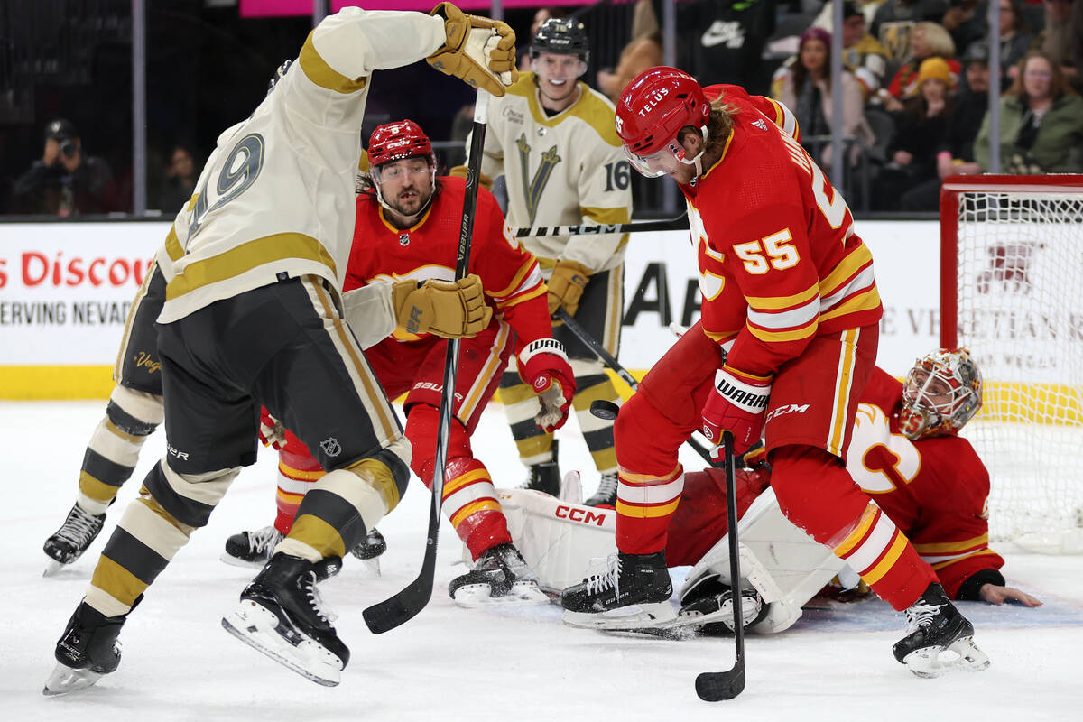 Flames defenseman Noah Hanifin (55) keeps the puck out of the net while Golden Knights center I ...