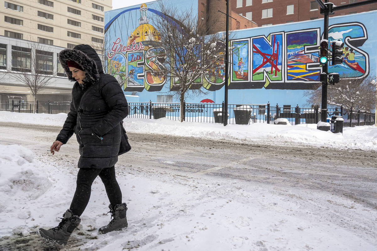 A woman walks past a mural in downtown Des Moines, Iowa, Saturday, Jan. 13, 2024. (AP Photo/And ...