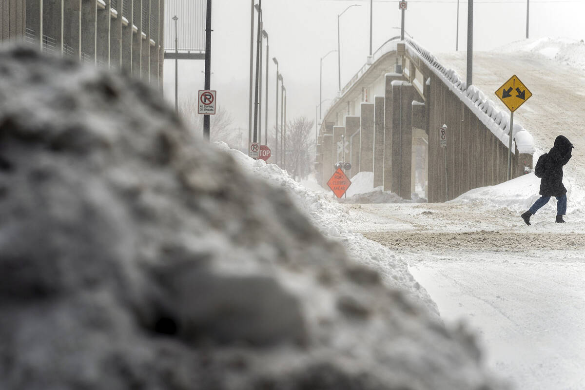 A woman walks through snow in downtown Des Moines, Iowa, Saturday, Jan. 13, 2024. (AP Photo/And ...