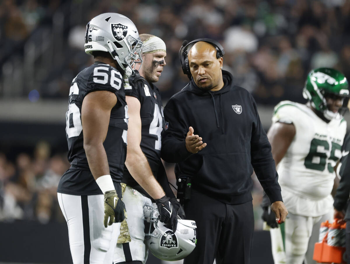 Raiders Interim Coach Antonio Pierce talks to linebackers Amari Burney (56) and Robert Spillane ...