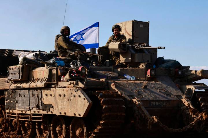 Israeli soldiers in an armored vehicle on the Israeli border with Gaza, return from the Palesti ...