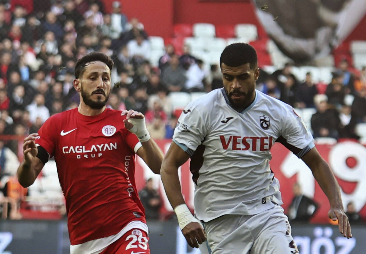 Antalyaspor's Sagiv Jehezkel, left, vies for the ball with Trabzonspor's Rayyan Baniya during a ...