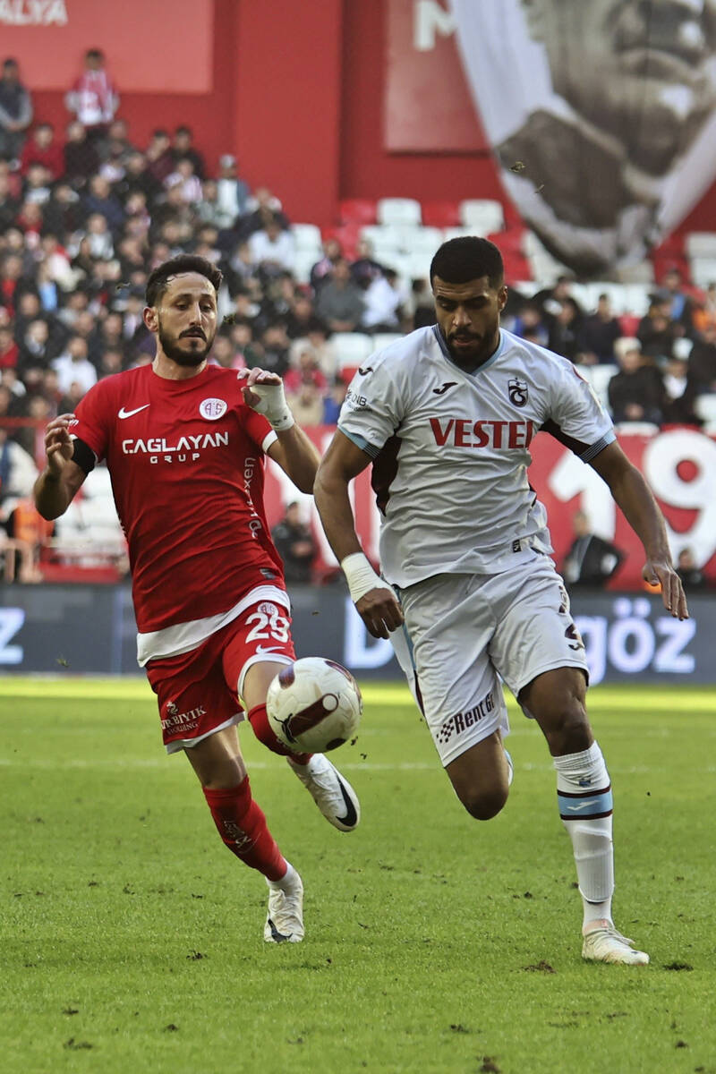 Antalyaspor's Sagiv Jehezkel, left, vies for the ball with Trabzonspor's Rayyan Baniya during a ...