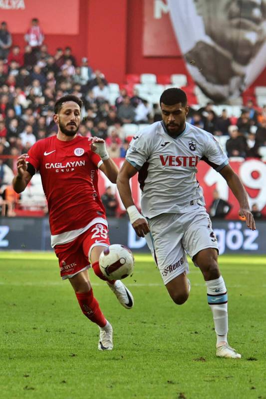 Antalyaspor's Sagiv Jehezkel, left, vies for the ball with Trabzonspor's Rayyan Baniya during a ...