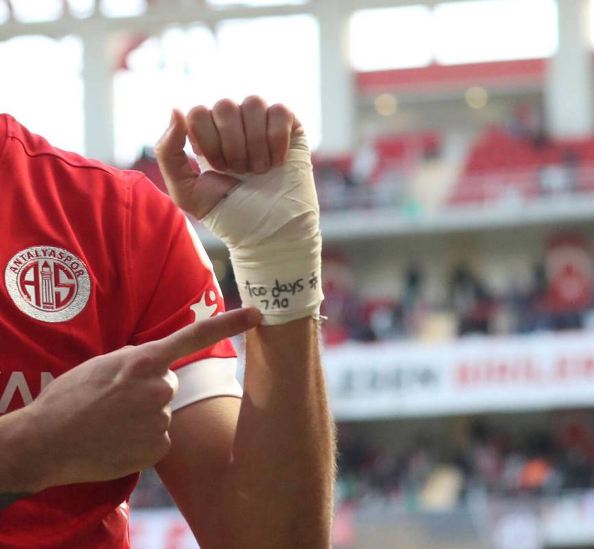 Antalyaspor's Sagiv Jehezkel points a message in his bandage that reads: "100 days. 7.10&q ...