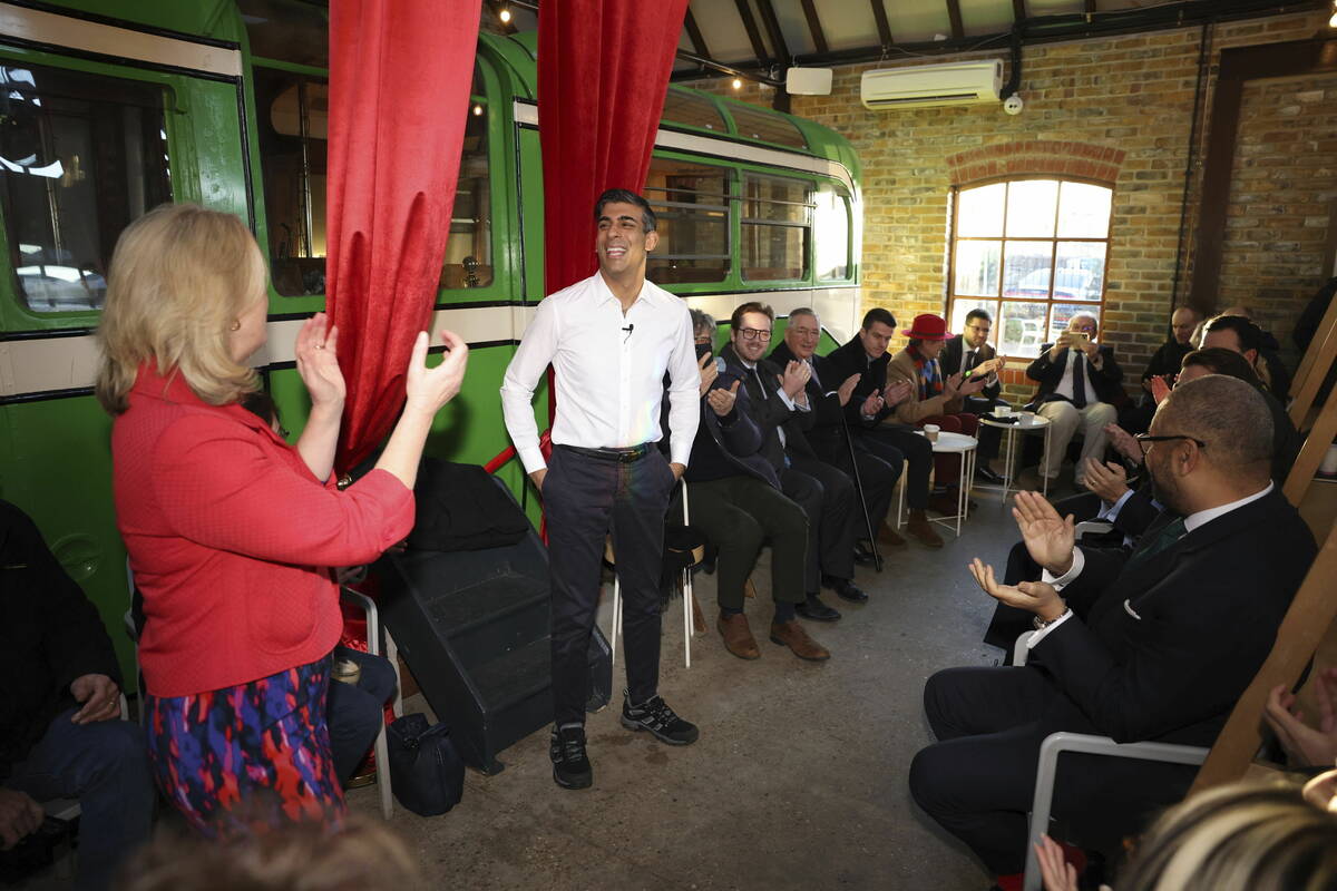 Britain's Prime Minister Rishi Sunak, center, reacts during his visit to The Boatyard in Leigh- ...