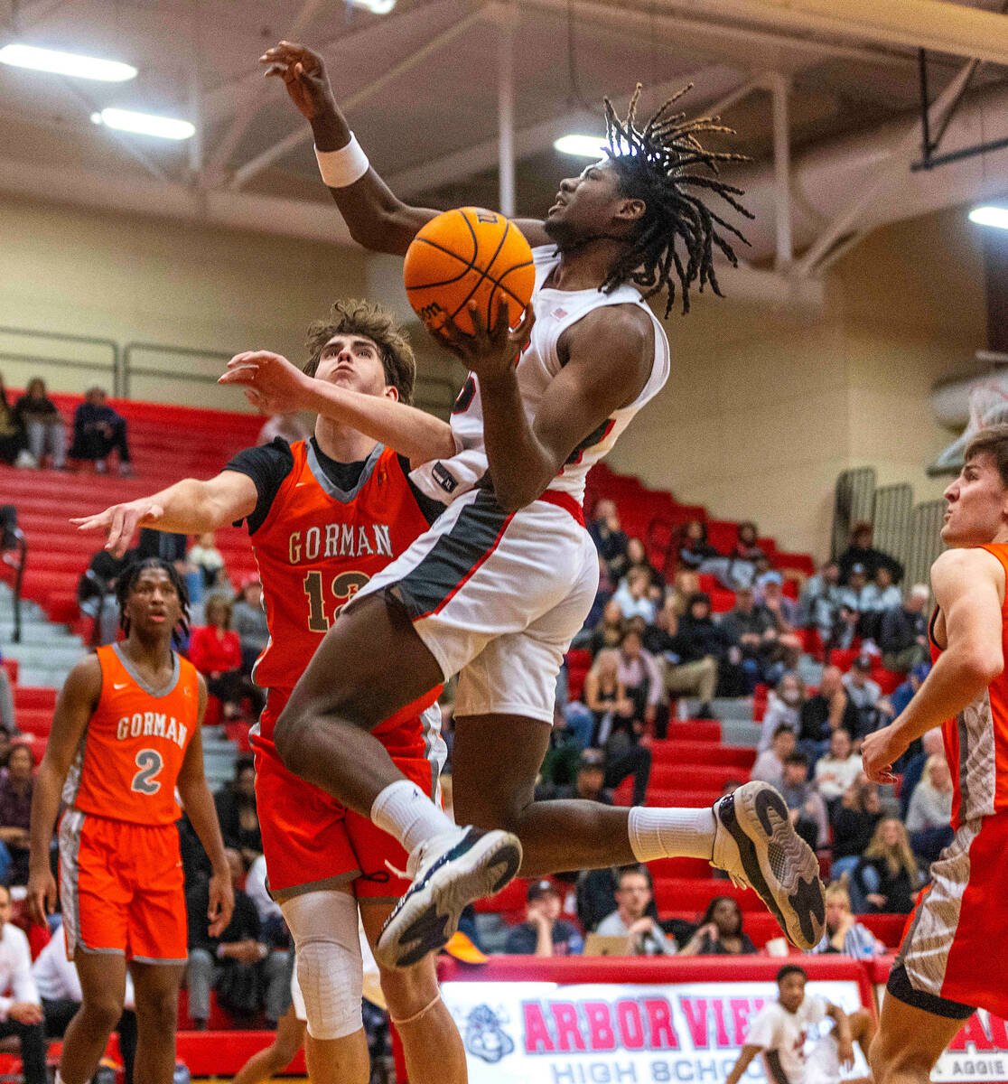 Arbor View forward Pharaoh Compton (5) elevates past Bishop Gorman forward Noah Westbrook (13) ...