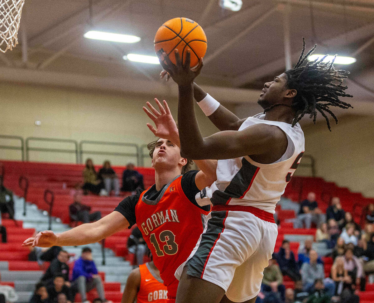 Arbor View forward Pharaoh Compton (5) elevates past Bishop Gorman forward Noah Westbrook (13) ...