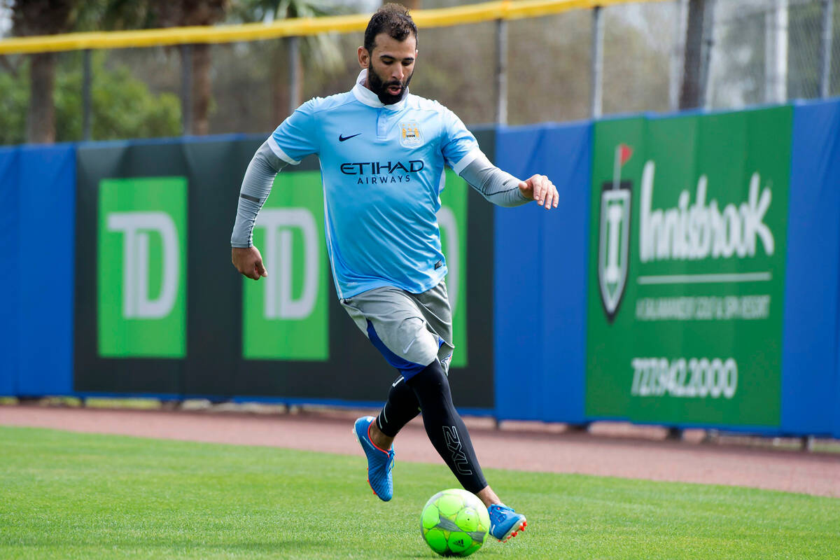 FILE - Toronto Blue Jays' Jose Bautista takes to the outfield with a soccer ball after rain sho ...