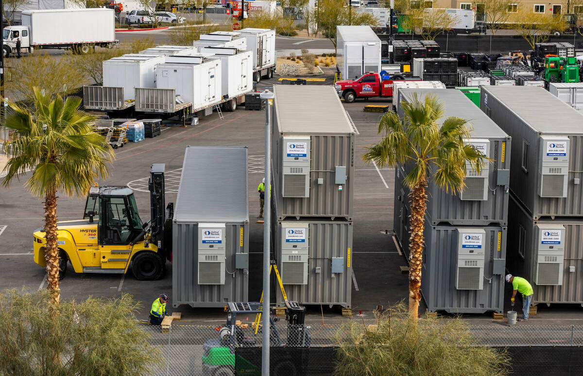 Containers are moved into place and secured in a parking lot as Super Bowl preparations continu ...