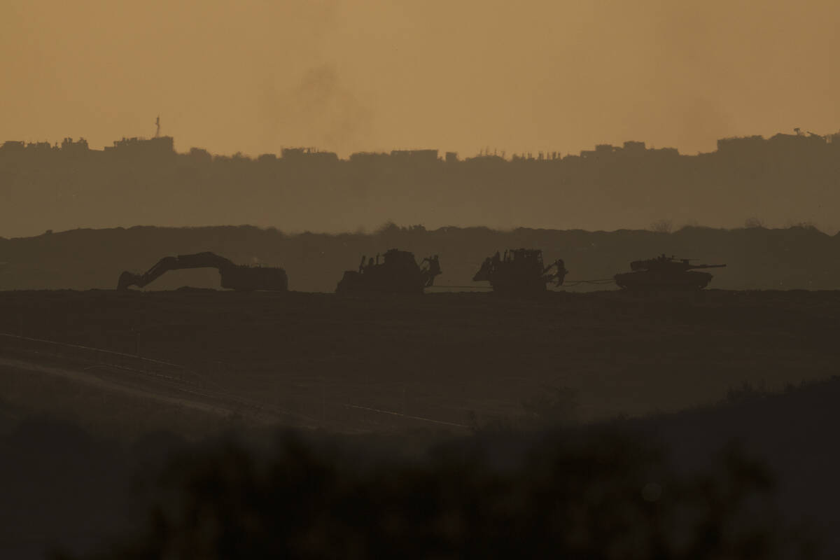 An Israeli tank and bulldozers move inside the Gaza Strip as seen from southern Israel, Tuesday ...