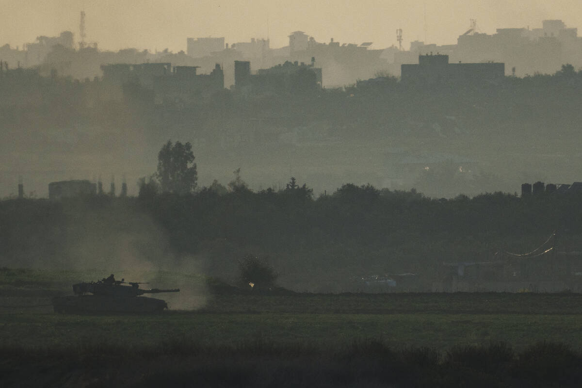 An Israeli tank moves inside the Gaza Strip as seen from southern Israel, Tuesday, Jan. 16, 202 ...