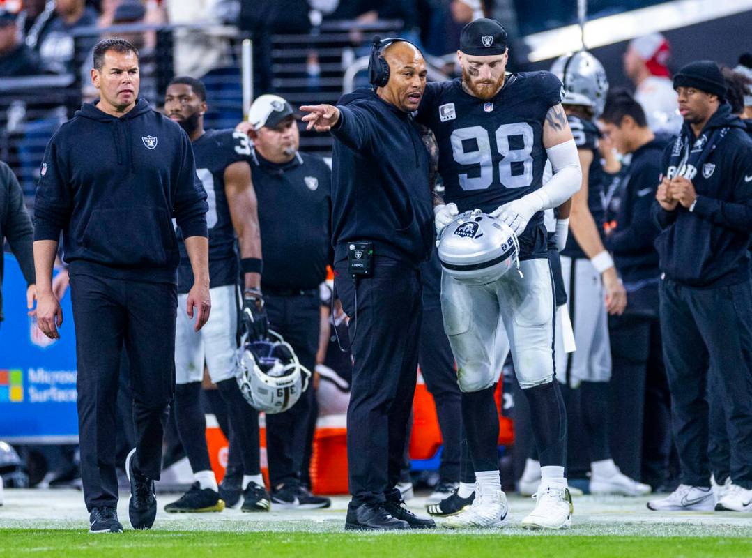 Raiders head coach Antonio Pierce talks with defensive end Maxx Crosby (98) on the sidelines ag ...