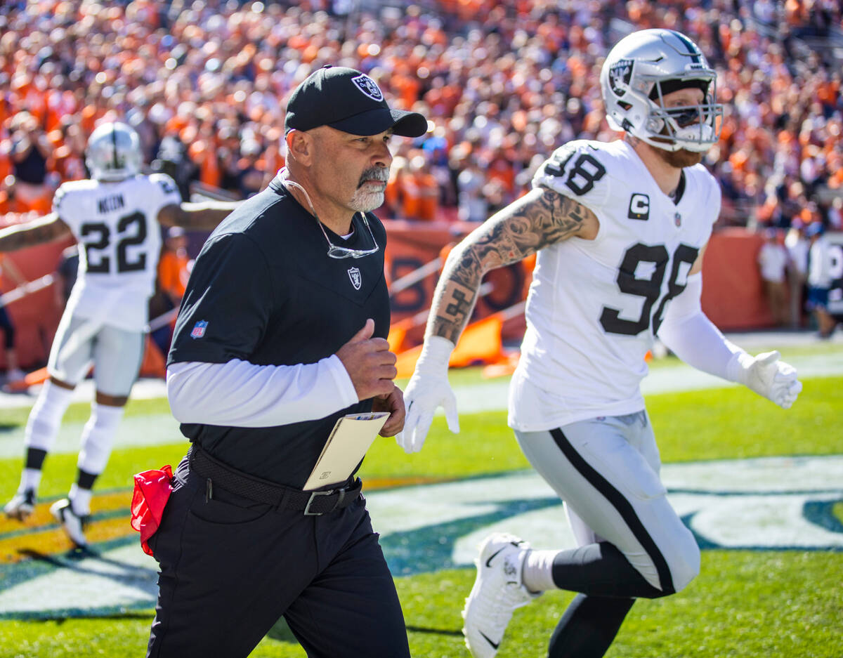 RaidersÕ interim head coach Rich Bisaccia runs out onto the field beside defensive end Max ...