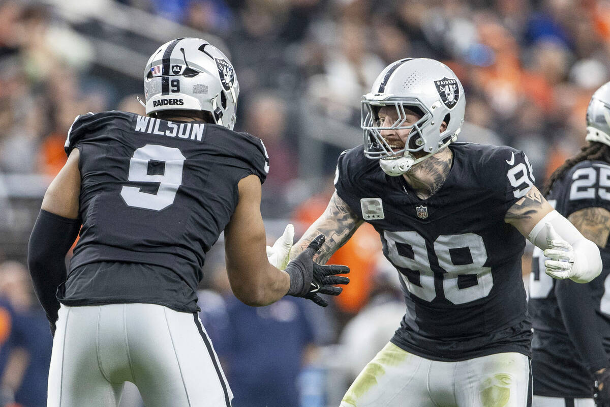 Raiders defensive end Maxx Crosby (98) congratulates defensive end Tyree Wilson (9) on his sack ...