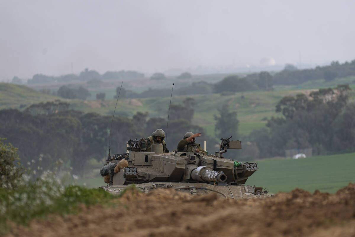 Israeli army tank moves near the Israeli-Gaza border, in southern Israel, Wednesday, Jan. 17, 2 ...