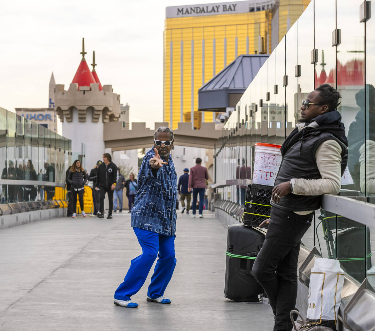 Dancer Johnnie Morisette Jr. performs as others walk along the pedestrian bridge leading from N ...