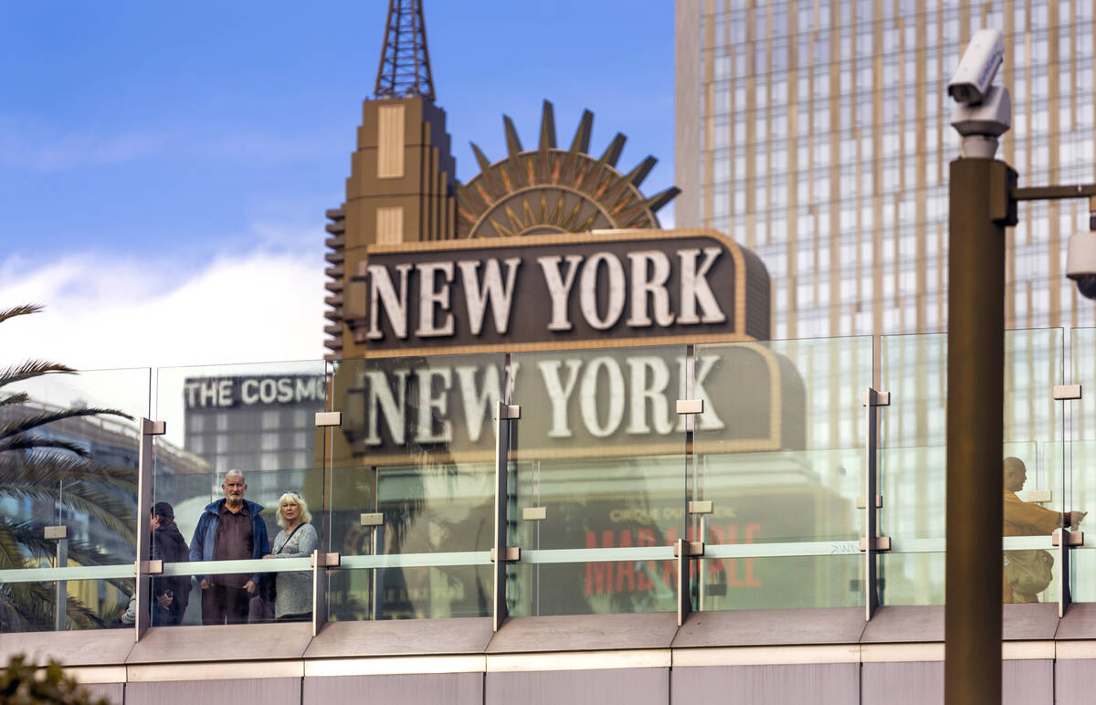 A couple stops to check out the view along the pedestrian bridge leading to New York New York o ...