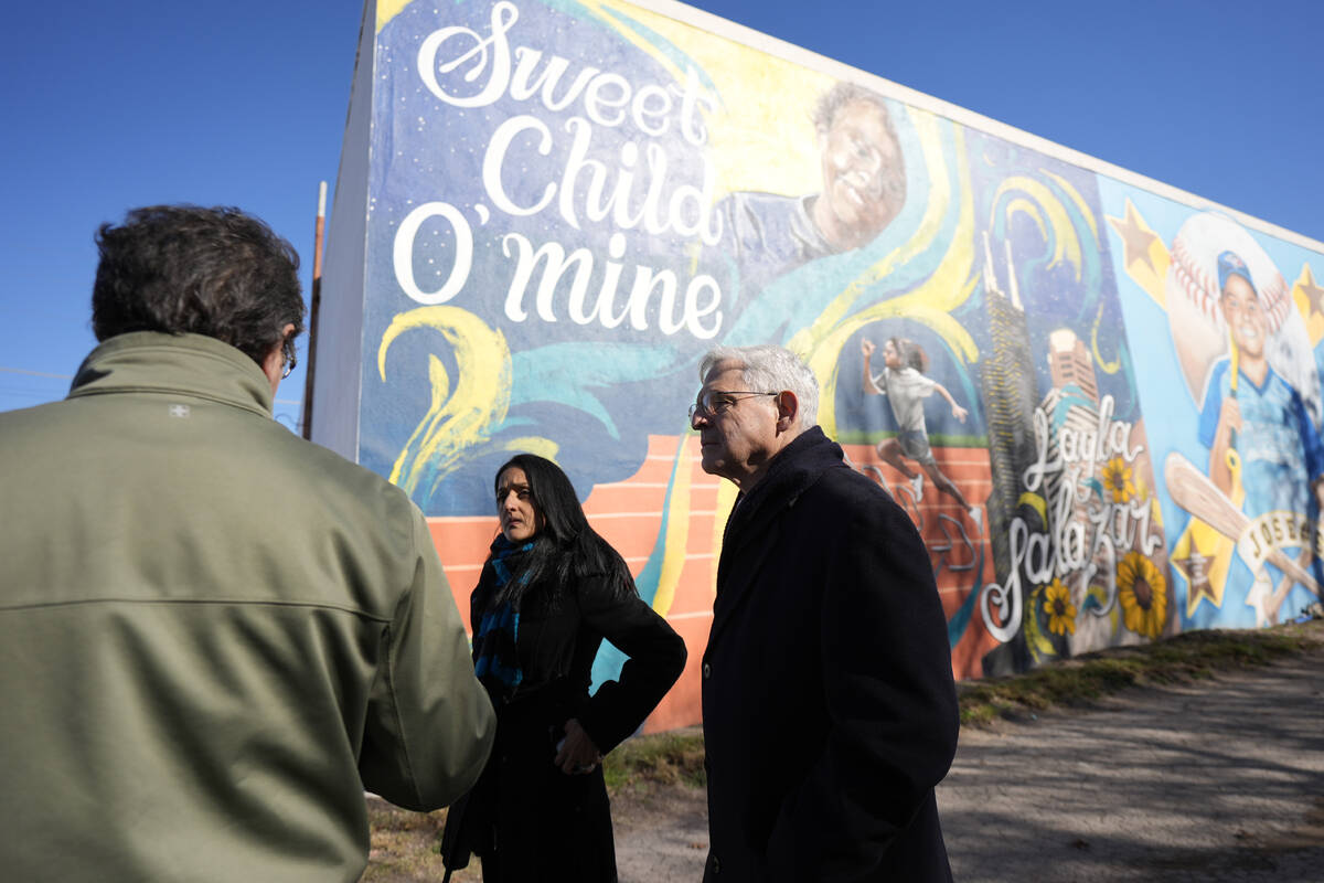 Artist Abel Ortiz, left, gives Attorney General Merrick Garland, right, and Associate Attorney ...