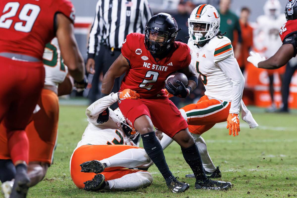 North Carolina State's Michael Allen (2) is tackled by Miami's Wesley Bissainthe (31) during th ...