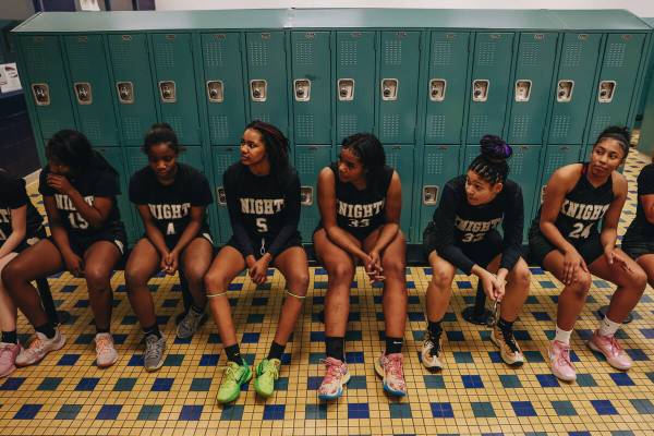 The Democracy Prep girls basketball team sits in the locker room during halftime of a game agai ...