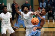 Rancho guard Jordan Childress (3) swats down a shot by Canyon Spring guard Henry King (14) duri ...