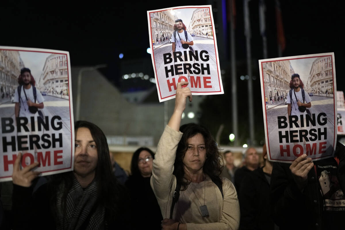 People hold signs showing a picture of a hostage during a demonstration calling for the release ...
