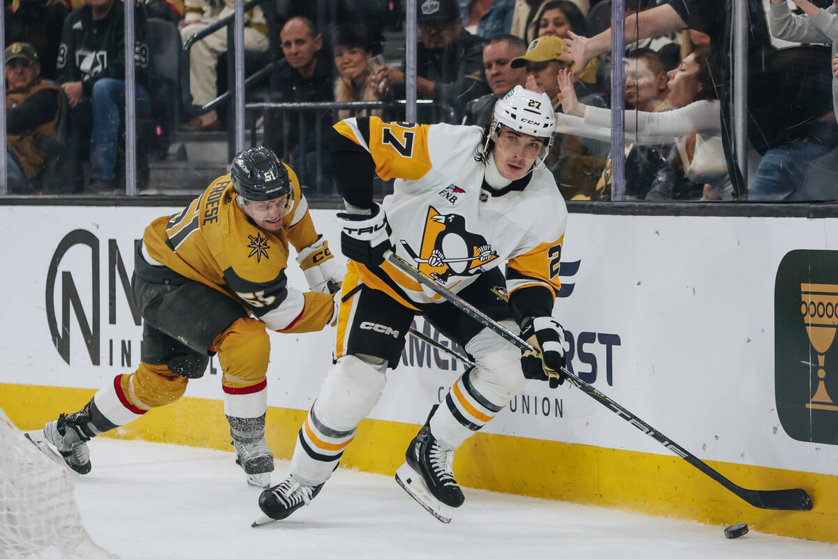 Pittsburgh Penguins defenseman Ryan Graves (27) shuffles the puck as Golden Knights center Byro ...