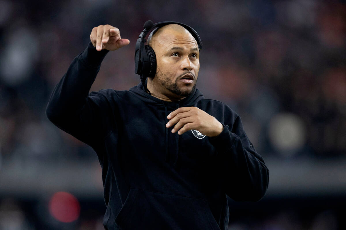 Raiders interim head coach Antonio Pierce gestures as he speaks in his headset during the first ...