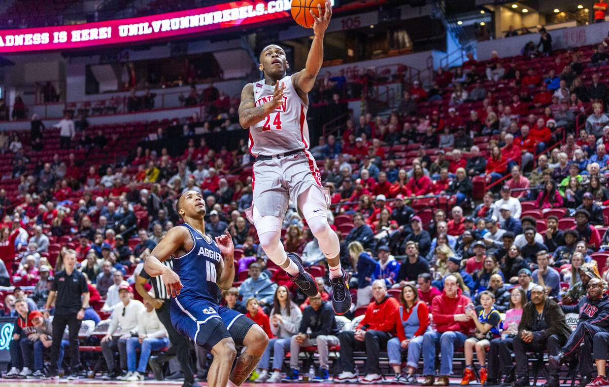 UNLV guard Jackie Johnson III (24) elevates for a basket over Utah State Aggies guard Darius Br ...